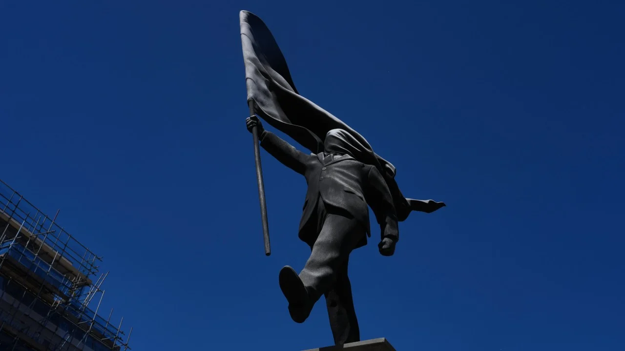 New Banksy statue of man blinded by flag draws crowds in London